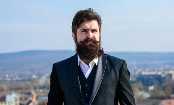 Invest in stylish appearance. Grow thick beard fast. Man bearded hipster wear formal suit blue sky background. Vintage style long beard. Facial hair beard and mustache care. Beard fashion trend