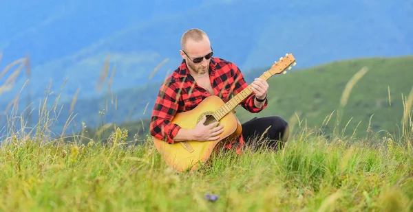 Keep calm and play guitar. Man with guitar on top of mountain. Acoustic music. Music for soul. Playing music. Sound of freedom. In unison with nature. Musician hiker find inspiration in mountains