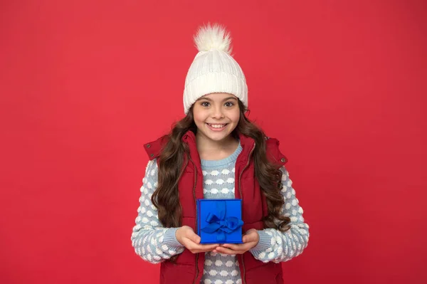 Kerstcadeaus. Vakantie souvenirs concept. Cadeau voor een vrouw. Geïnspireerd voor het goede doel. Kerstcadeau idee. Wintervakantie. Happy kid winter outfit houden geschenkdoos rode achtergrond. Wenslijst. Vakantieseizoen — Stockfoto