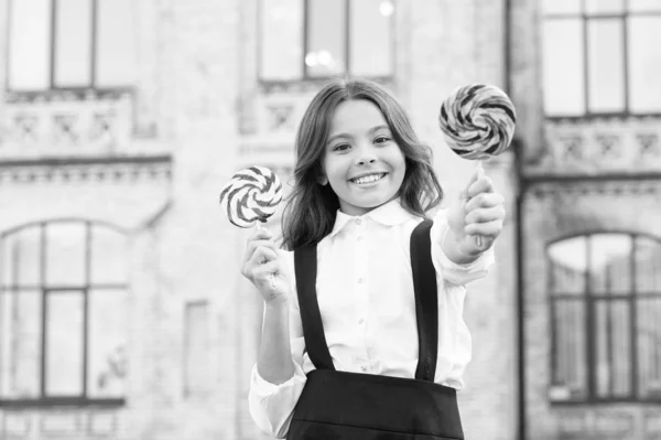 Crazy about sweets. Sugar addiction. Cheat meal day. Happy kid with sweet candy. Kid child holding lollipops candy outdoors. Happy kid with candy. School nutrition. Calories and energy. Both mine