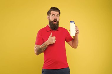 Tamamen organik bir deneyim. Adam yakışıklı sakallı berber şişe şampuan duş jeli tutun. Erkekler için şampuan kremi. Kozmetik plastik konteyner. Berber salonu. Kuaför berber konsepti