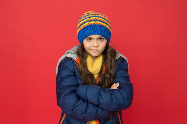 I do not think so. Strict and serious baby. Little girl wear winter clothes red background. Childhood concept. Emotional girl long hair knitted hat. Teen girl casual style. Emotions and mood