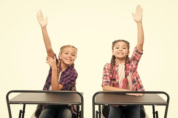 Hef de handen op om te antwoorden. Studenten klasgenoten zitten op de tafel. Terug naar school. Privéschool concept. Basisschool onderwijs. Geniet van het proces van studeren. Kleine meisjes school vrienden studeren samen — Stockfoto