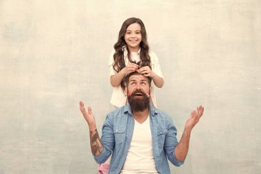 Senin kadar bireysel. Küçük kız hippi grisi arka planda saç yapıyor. Küçük çocuk ve hippi tarzı sakallı bir adam. Sevimli kızı ve hippi babası. Berber dükkanı. Kendin ol, hipster ol.