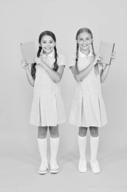 retro üniformalı mutlu arkadaşlar. vintage çocuk moda. Okula geri dön. küçük kızlar çalışma kitabı ve not defteri tutun. çocuklar için ansiklopedi kitap. Küçük kızlar edebiyatı sever. eski okul. Bilgiye doğru