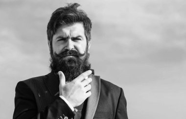 Yüz saç sakal ve bıyık bakımı. Sakal moda trendi. Şık görünüm yatırım. Hızlı kalın sakal. Adam hipster giyim resmi elbise mavi gökyüzü arka plan sakallı. Vintage tarzı uzun sakal