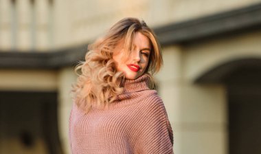 Yumuşaklığın tadını çıkar. Sarışın kız, güz kıyafetiyle makyajlı. Örgü giyme konsepti. Vogue modeli. Kaşmir yün kazak. Sıcak, büyük kazaklar. Kadınlar kazak giyer. Uzun kazak ya da elbise.