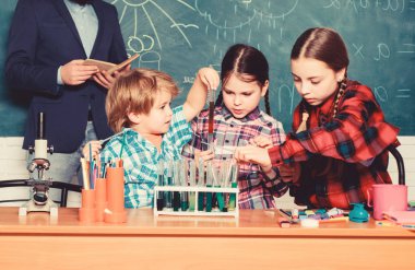 Akıllı ve emin. mutlu çocuk öğretmen. geri okula. laboratuarda kimyasallar veya mikroskop ile denemeler yapmak. Biyoloji Eğitimi. Mikroskop. Biyoloji Okulu Laboratuar donanımları