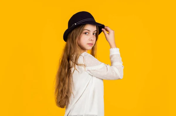 Självsäker och elegant skönhet. retro flicka gul bakgrund. Glad liten unge retro hatt. vintage mode utseende. sommarkollektion. barnlångt hår. skönhet och stil. Lycklig barndom. Ung och bekymmerslös — Stockfoto