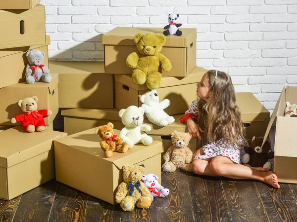 Playroom concept. Moving in. Delivering service. Feeling good at home. All she needs are toys. Home is where are my toys. Teddy bear collection. Sweet home. Girl child relaxing after unpacking boxes — Stock Photo, Image