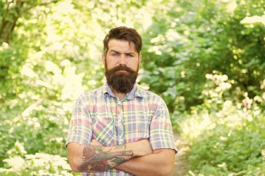 Eko yaşam tarzı. Çevre ile birleşmiş. Yakışıklı bir oduncu. Yaz ormanında sakal ve bıyık. Yaz tatili kavramı. Sakallı hippi yeşil ağaçlar. Adam yaz doğasında rahatlıyor.