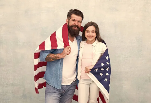 独立記念日の祝日。アメリカ人はどのように独立記念日を祝うのですか。宇佐旗を持つ父と娘。愛国的な家族だ独立記念日は家族が再会し、リラックスするチャンスです — ストック写真