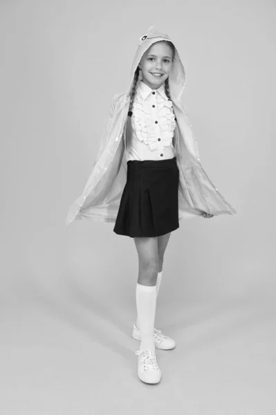 Chaqueta de colegiala con capucha yendo a la escuela. Ropa impermeable. Niña feliz usa impermeable. La lluvia no es un obstáculo. Capa impermeable. Tejido impermeable para su comodidad. Accesorio impermeable —  Fotos de Stock