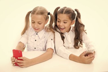 Öğrenciler için blog. Akıllı telefondan yeni blog yazıları yazan küçük çocuklar. Küçük blogcular sınıf blogunu tutuyor. Akıllı kızlar mobil aygıt aracılığıyla bloglarını çevrimiçi sosyal ağa yüklüyorlar