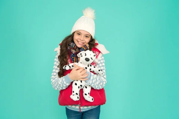 Soñando con un perro de verdad. Tienda o tienda de juguetes para niños. Estilo invierno. Diversión infantil. Hermosa cara sonriente de bebé. Tienda de mascotas. Su juguete favorito. Niño feliz sostener juguete suave. Niña sonrisa con juguete perro — Foto de Stock