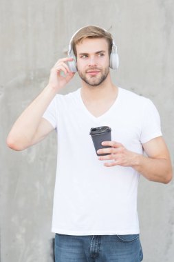 Katlanabilir Stereo kulaklıklar. Gürültü Azaltma. Modern ve çağdaş müzik. Kablosuz kulaklık. Yakışıklı adam kulaklık takıyor gri arka plan. Erkek öğrenci modern müzik dinler. Modern teknoloji
