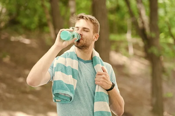 Su insan sağlığı için vazgeçilmezdir. Fit atlet açık eğitim sırasında su şişesinden bir içki olan. Susamış sporcu sıcak yaz gününde saf su içiyor. Vücut su dengesini korumak — Stok fotoğraf