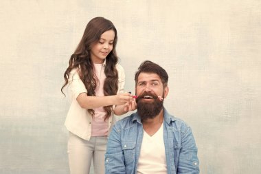 Saçı bana bırak. Küçük çocuk babasının saçını yapıyor. Sakallı adamın küçük çocuk tarzı bıyığı. Ailede çocuk büyütmek. Çocuk ve çocukluk. Kuaför salonu. Berber Dükkanı