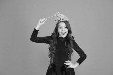 Lüks içinde şımarın. Kraliyet ve lüks. Uzun kıvırcık saçlı mutlu kız. Küçük prenses sihirli değneği tutuyor. Peri masallarındaki sihirli kraliçe. Sadece bir dilek tut. Bütün hayaller gerçek olur. Havalar ve zarafetler