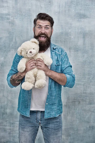 Toys shop concept. Happy birthday. Handsome hipster hold lovely bear toy. Valentines day. Present for your partner. Man with beard happy face carry gift toy. Playful mood. How to take care of someone