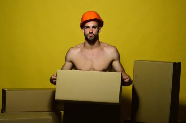 Kararlı maço kask takıyor. Çıplak vücutlu bir adam.