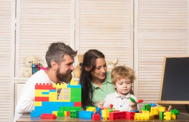 Baba, anne ve oğul açık tahta arka planda oyun odasında..