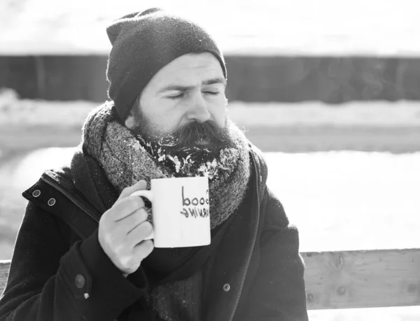 Frown man drinks from cup on snowy winter day outdoors on natural background — 스톡 사진