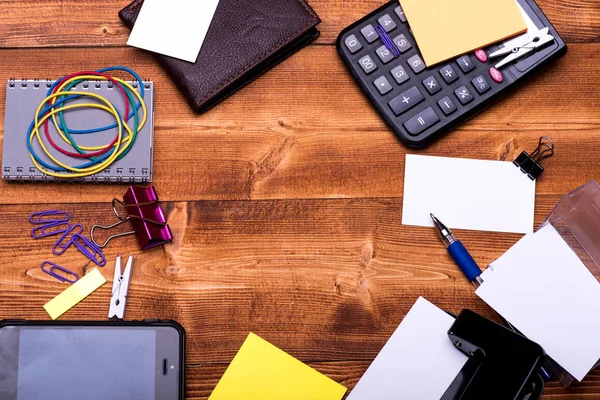 Office tools on wooden background, top view and copy space.