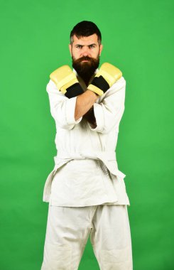 Karate man with serious face in uniform and boxing gloves