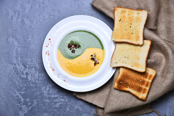 Sopa de espinacas y crema de calabaza sobre fondo de textura gris. — Foto de Stock