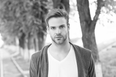 Temiz görünümlü. Yakışıklı, beyaz bir adam parkta yürüyor. Sakallı adam gündelik tarzda. Saç bakımını düzenlemek ve kıllandırmak. Berber dükkanı servisi. Yakışıklı maço. bahar erkek modası. Şık, tıraşsız adam.