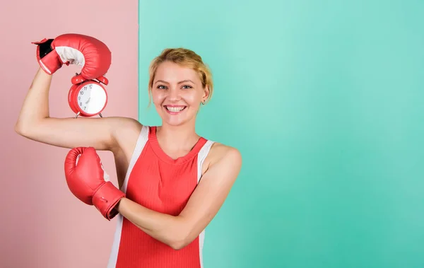 Puntualità ed efficienza personale. Ragazza pugile tenere sveglia. energia mattutina. Stabilire l'ora dell'orologio. copiare spazio. E 'ora di combattere. tempo per il successo. vincere la giornata. Guanti da boxe donna felice — Foto Stock