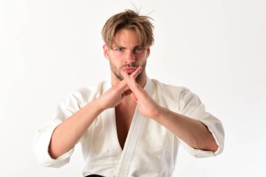 Adam beyaz kimonoyla poz veriyor. Ciddi yüzlü adam.