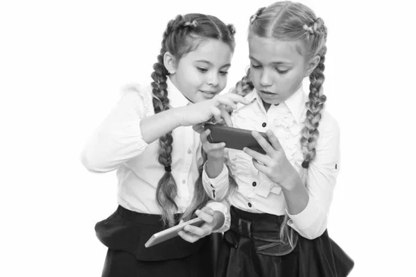 Chicas uniforme escolar navegar por Internet. La vida moderna. Las colegialas utilizan teléfono inteligente móvil de Internet. Teléfono inteligente de aplicación escolar. Adicción móvil. Red mundial. El recurso de Internet tiene peligros para los niños — Foto de Stock