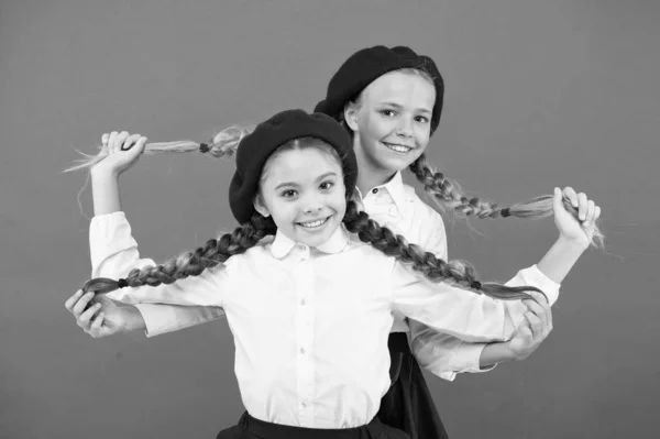 Amizade significa apoio. Meninas melhores amigos no fundo vermelho. Os verdadeiros amigos estão sempre ao teu lado. Bonito brincalhão irmãs alunas se divertindo. Crianças tranças longas penteado colegas amigos — Fotografia de Stock