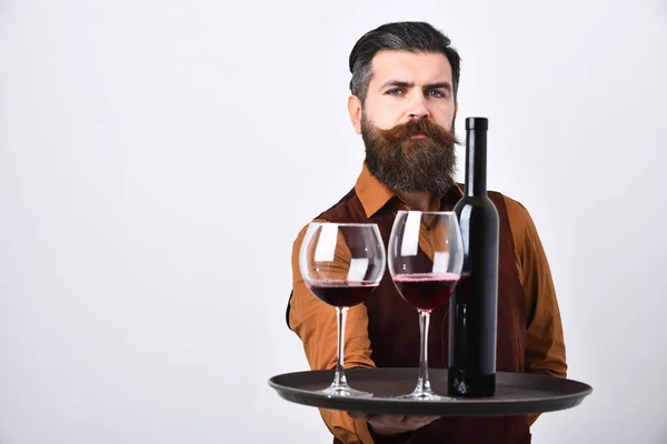 Waiter with tray, bottle and glass of red wine
