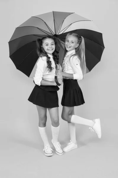 Dia chuvoso. Feliz infância. Hora da escola. Guarda-chuva arco-íris. Vida colorida. Estudantes feliz grande guarda-chuva. Previsão do tempo de queda. Lugar para nós os dois. Acessório de moda. Meninas amigas com guarda-chuva — Fotografia de Stock