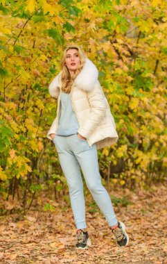 Model örgü giysileri arka planda kalır. Doğada rahatlayan, örgü elbise ve ceket giyen bir kız. Dinlenmek için giysiler. Kadınlar parkta sonbahar sezonunun tadını çıkarırlar. Sıcak örgü. Pratik ve konforu hisset.