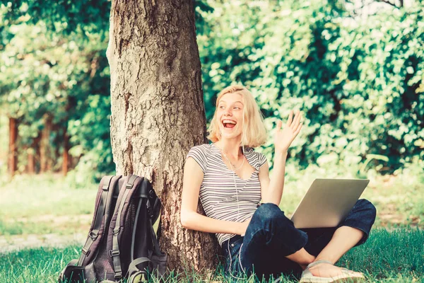 Природа главное благополучие и способность быть продуктивным. Работа в летнем парке. Девушка работает с ноутбуком в парке. Причины, по которым ты должен вынести свою работу наружу. Студентка сидит на траве во время учебы — стоковое фото