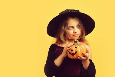 Cadı kostümü giymiş çocuk ve Jack O Lantern.