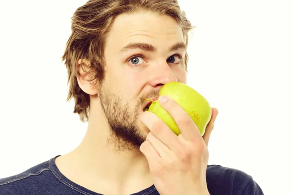 Hombre joven en camiseta azul mordiendo manzana verde grande — Foto de Stock