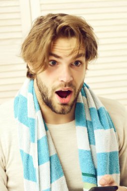 Beyaz perdelerde çizgili mavi beyaz havlusu olan adam.