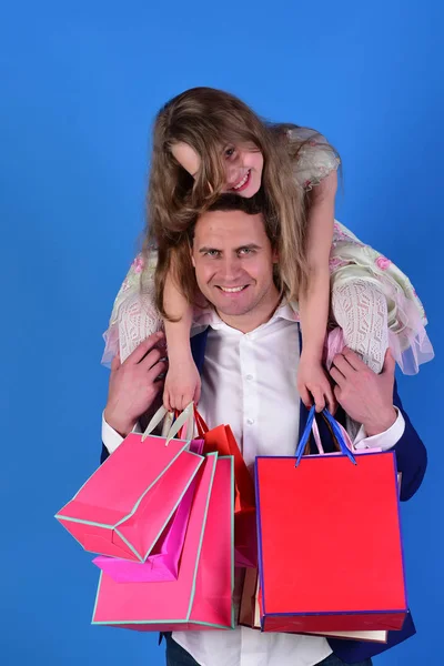 Schoolgirl sits on dads shoulders. Shopaholics, childhood and family — Stock Photo, Image