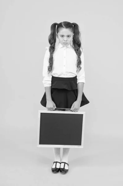 Sad news. Schoolgirl offended pupil informing you. School girl hold blank chalkboard copy space. Announcement and promotion. Girl school uniform hold blackboard. Back to school. Something happened