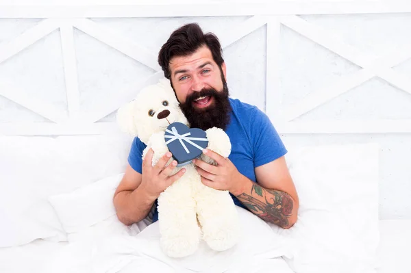 Tiempo libre. Caja de regalo para vacaciones. Bonito regalo para ti. Mañana de San Valentín. mi cumpleaños. Feliz adultez. concepto de compras en casa. Amor y felicidad. hombre barbudo osito de peluche en la cama —  Fotos de Stock