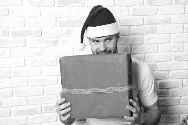 サンタの帽子で狡猾な顔をもつ男が赤いボックスを保持します。 — ストック写真