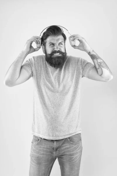 Make some noise. Sound is so loud. Bearded man listen to sound track. Hipster wear earphones playing sharp sound. Unpleasant sound. Music and technology — Stock Photo, Image