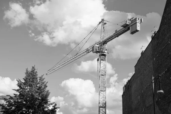 Plaats in aanbouw. Bouwkraan op bewolkte lucht. Kraanvogel voor de bouw. Gebouw aan het bouwen. Structuur toevoegen aan onroerend goed. Residentiële of niet-residentiële bouw — Stockfoto