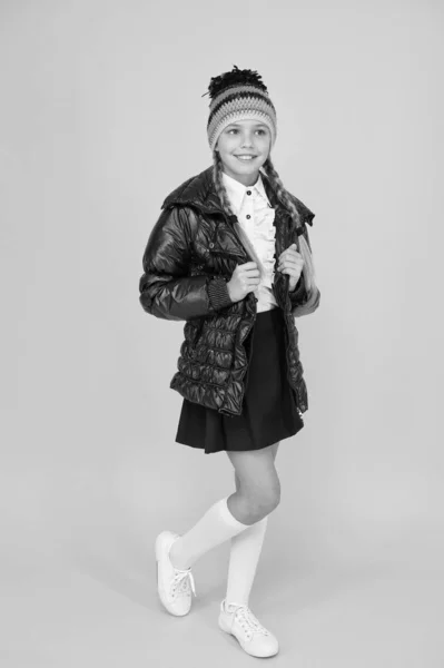 Mantenere la moda e accogliente. Bambina scolaretta in accogliente abito di moda su sfondo giallo. Look autunnale di piccola modella. Moda freddo per bambini. Siate cool in questo cappotto di lusso — Foto Stock