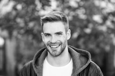 İnsanoğlu böyle görünmek ister. Sonbahar gününde mutlu bir adam. Yakışıklı adam sıradan bir şekilde gülümsüyor. Tıraşsız sakallı ve şık saç tıraşlı beyaz bir adam. Sonbahar modası. Yaşam biçimi